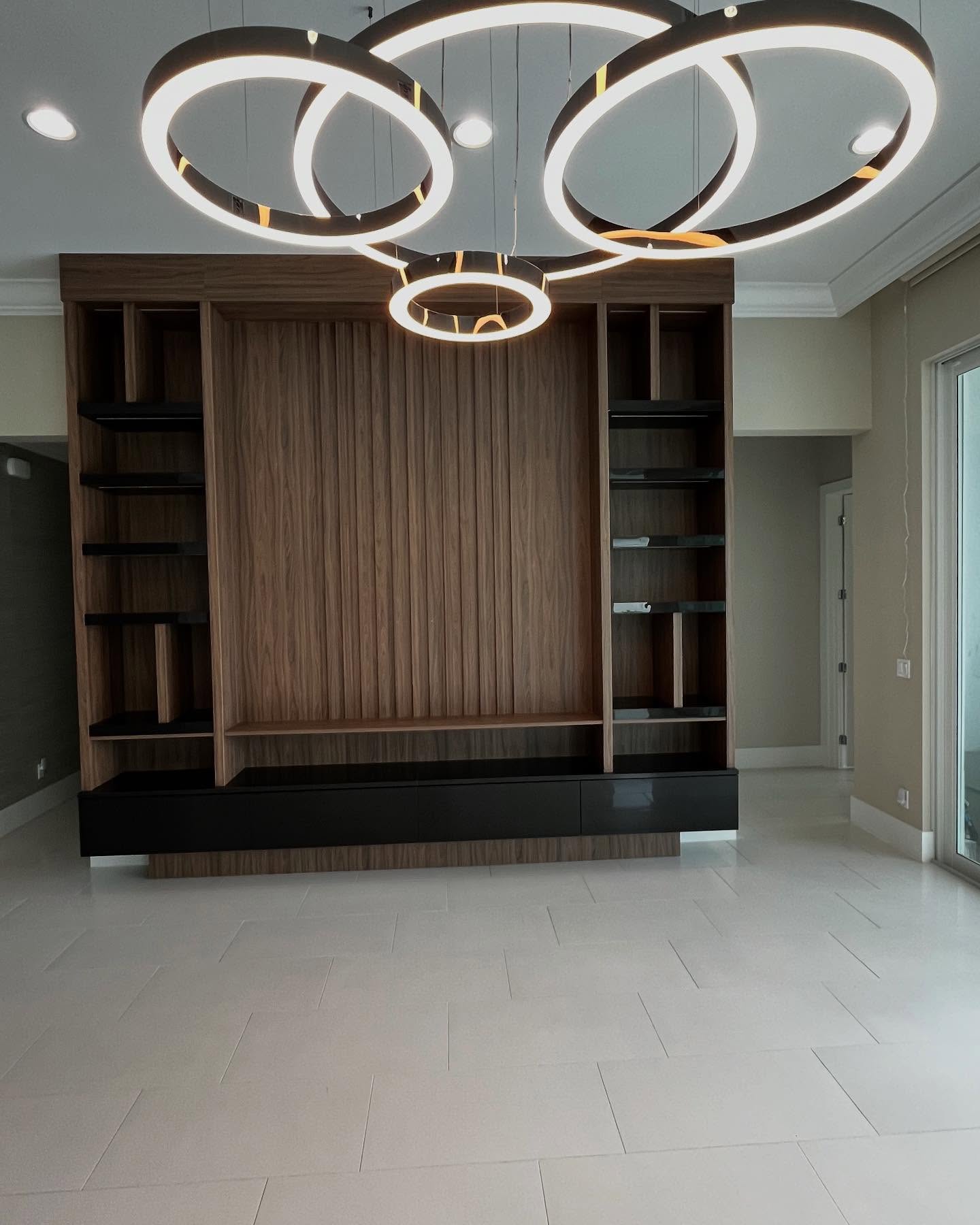 Walnut display cabinetry framed by sculptural lighting
