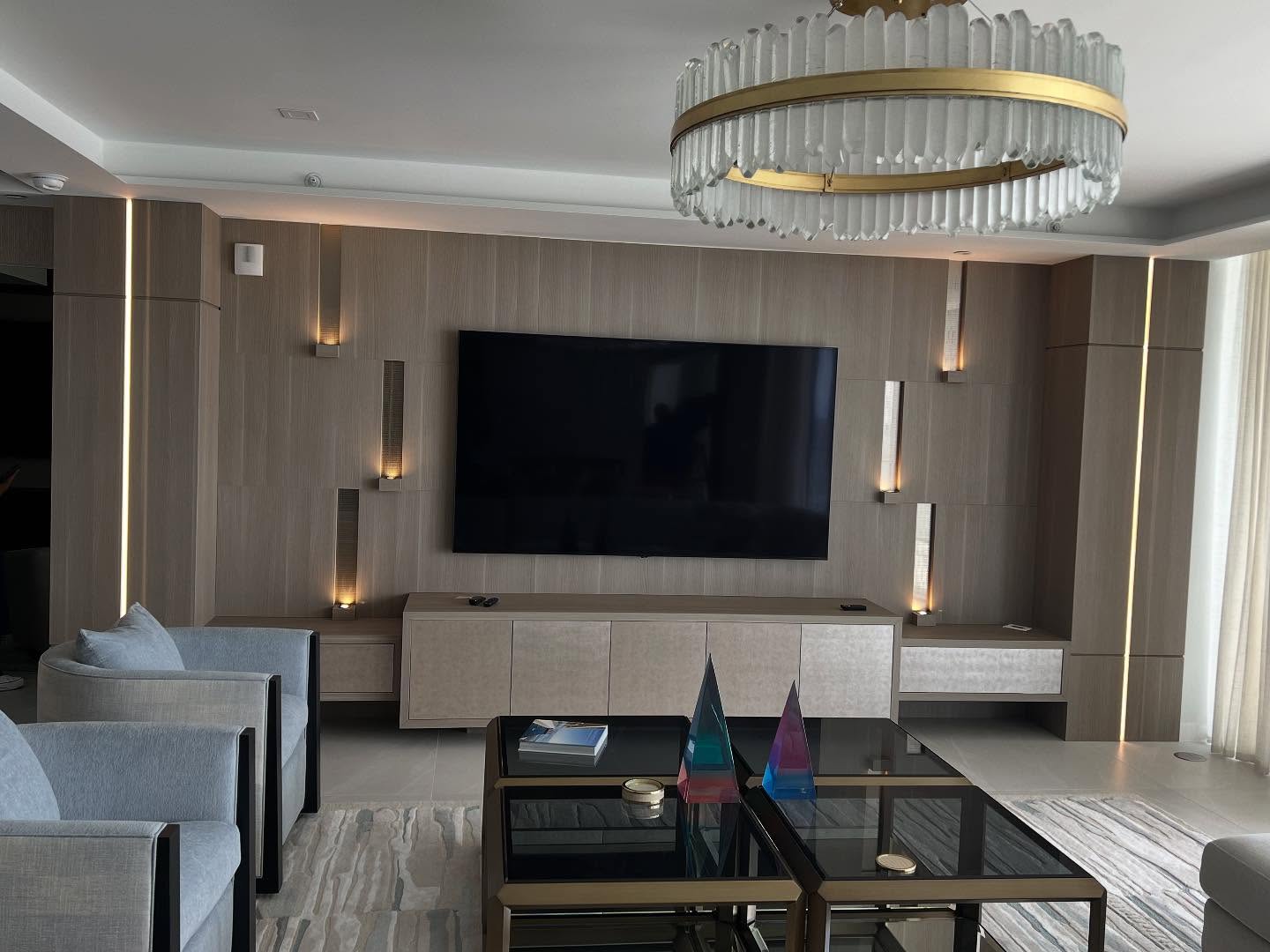 Full-width custom media wall with integrated lighting and storage