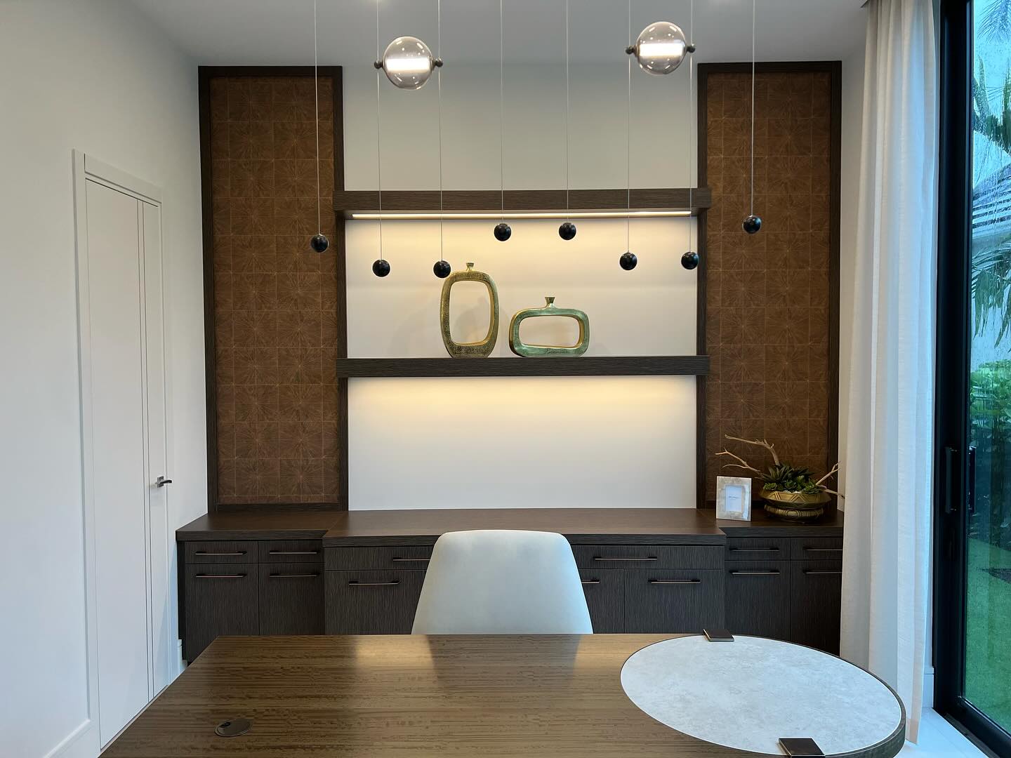 Custom home office with illuminated cabinetry and desk
